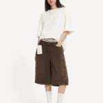 استایل مدل زنانه با ست اورسایز Alexander Wang سفید و قهوه‌ای و کفش کتانی متناسب.