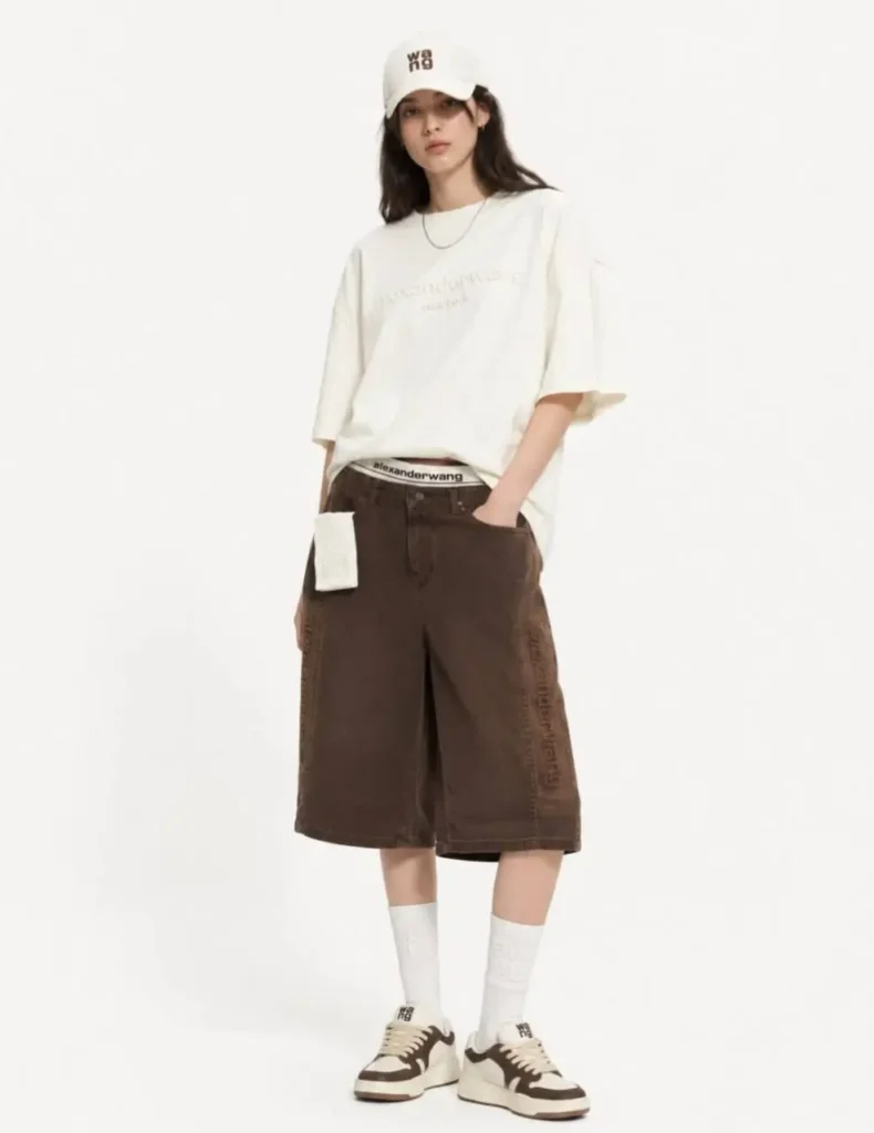 استایل مدل زنانه با ست اورسایز Alexander Wang سفید و قهوه‌ای و کفش کتانی متناسب.