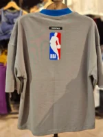 نمای پشت تیشرت NBA طوسی همراه با لوگوی بسکتبال و تگ اسنشیالز